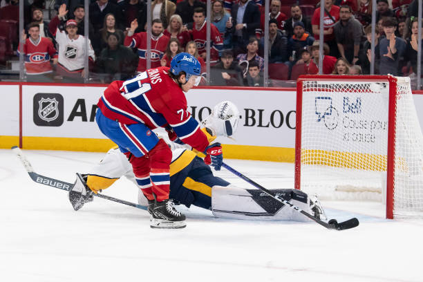 Jake Evans #71 of the Montreal Canadiens misses the net against Yaroslav Askarov #50 of the Nashville Predators