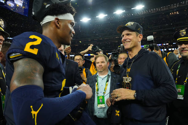 Michigan head coach Jim Harbaugh and Will Johnson (2)